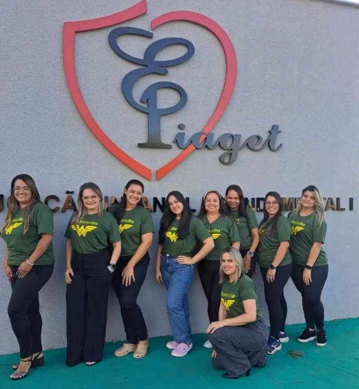 Equipe da Escola Piaget em frente à fachada da escola
